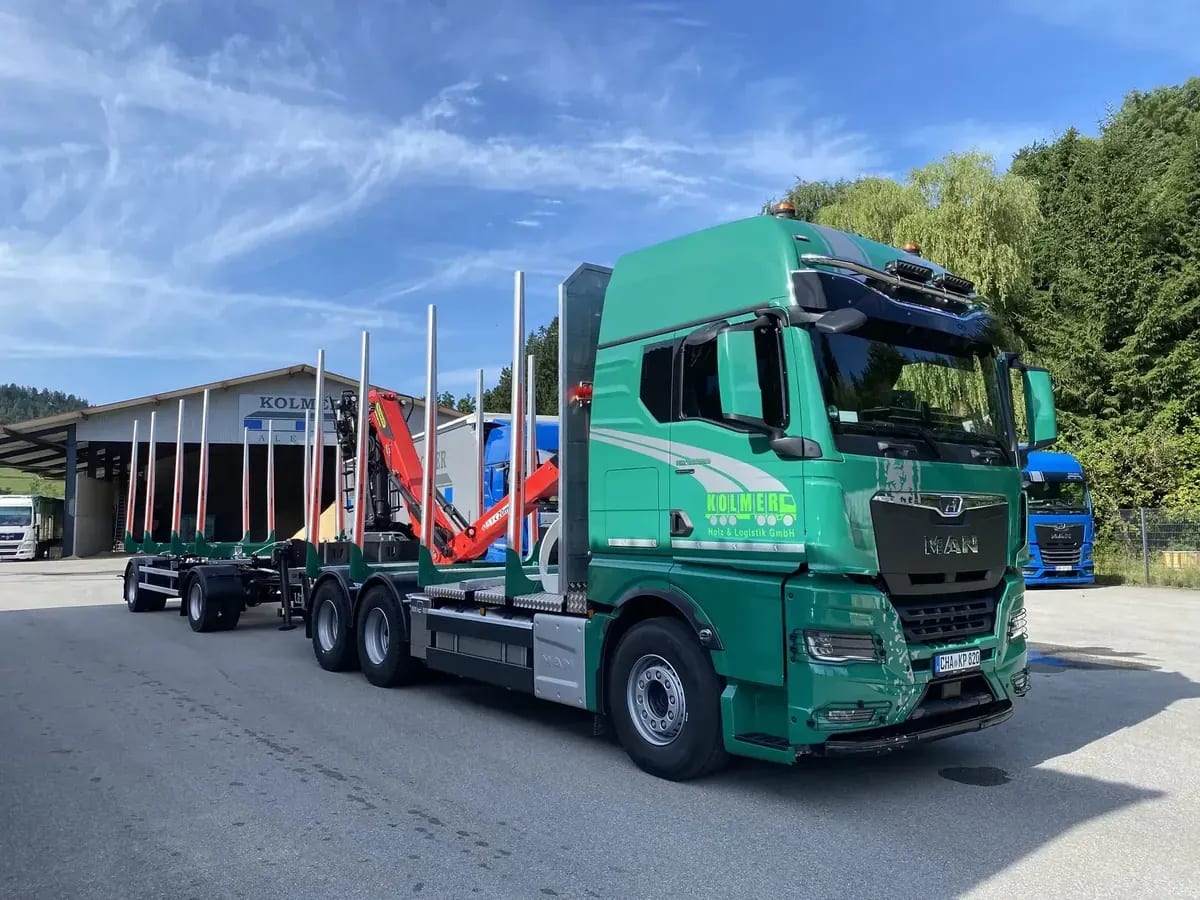Grüner MAN-Rundholz-LKW mit Kran vor der Halle von Kolmer in Miltach