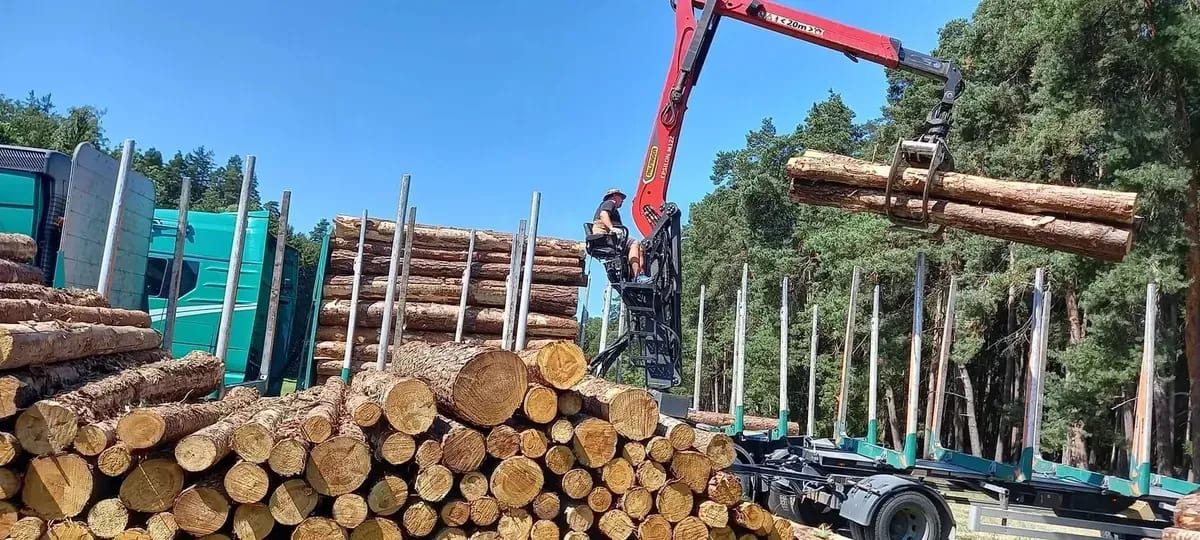 Kolmer-LKW verlädt Rundholz mit dem Ladekran am Holzlagerplatz